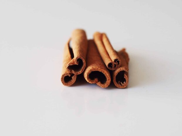 Close up view of cinnamon sticks arranged on a white surface