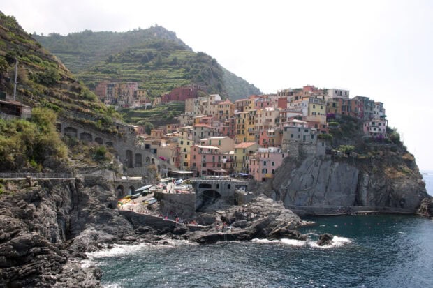 Colorful village of Cinque Terre with terraced hills and rocky coastline