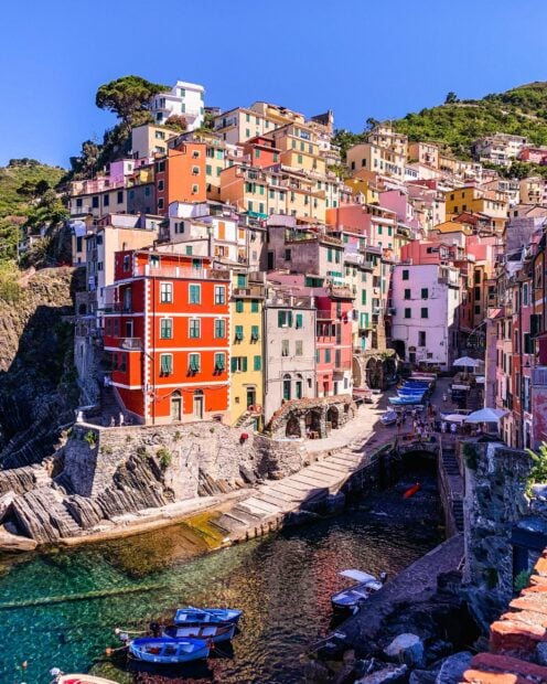 Colorful Cinque Terre town houses built on rocky coastline near clear water