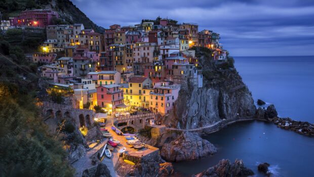 Colorful Cinque Terre village houses on cliffs lit up at dusk