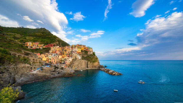 Colorful houses on the rocky coast of Cinque Terre with bright blue sea and sky