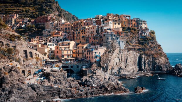 Colorful Cinque Terre town built on rugged cliffs by the sea with vibrant buildings and rocky shorelines