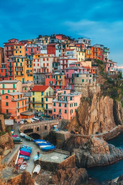 Colorful coastal village of Cinque Terre with boats along the rocky shore