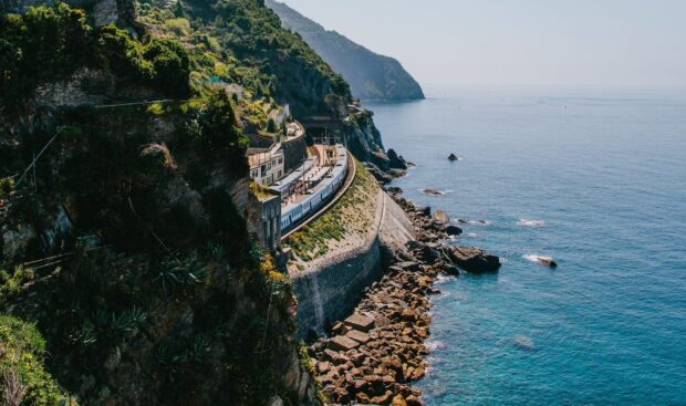 A scenic coastline with a train passing through the cliffside of Cinque Terre