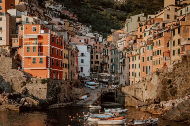 Colorful buildings of Cinque Terre village with boats docked by the sea
