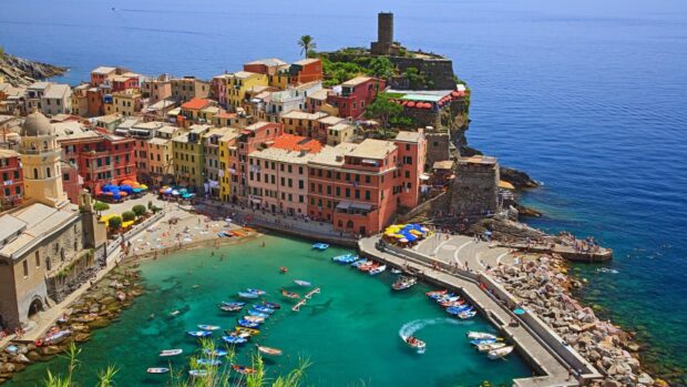 Colorful Cinque Terre town with boats docked in the turquoise sea bay