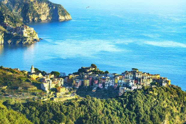 Colorful Cinque Terre townscape on rocky cliffs by the sea with bright blue water