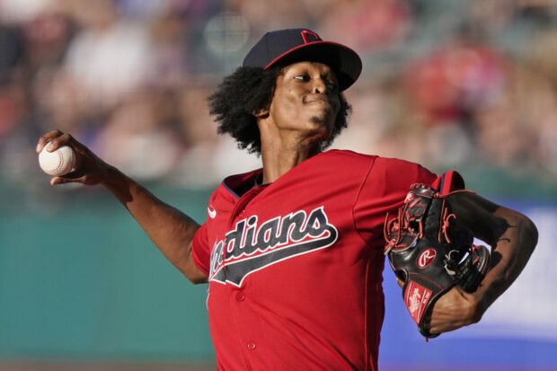 Cleveland Guardians player pitching the ball during a baseball game with a red jersey