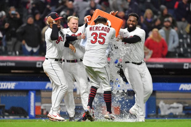 Cleveland Guardians players celebrating a victory with water splash after a baseball game