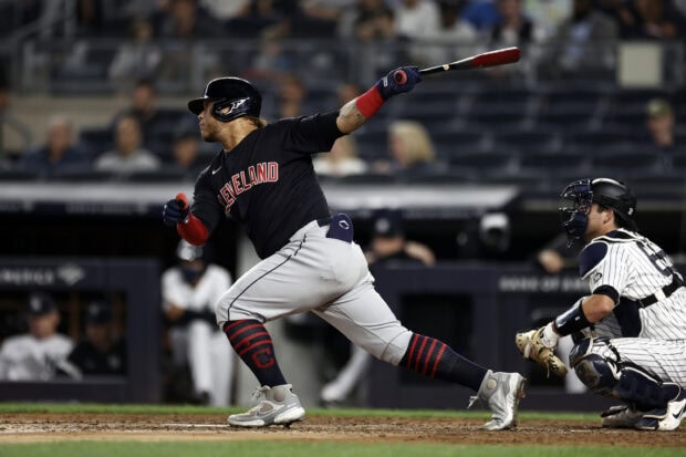A Cleveland Guardians player swinging a bat during a baseball game at the stadium