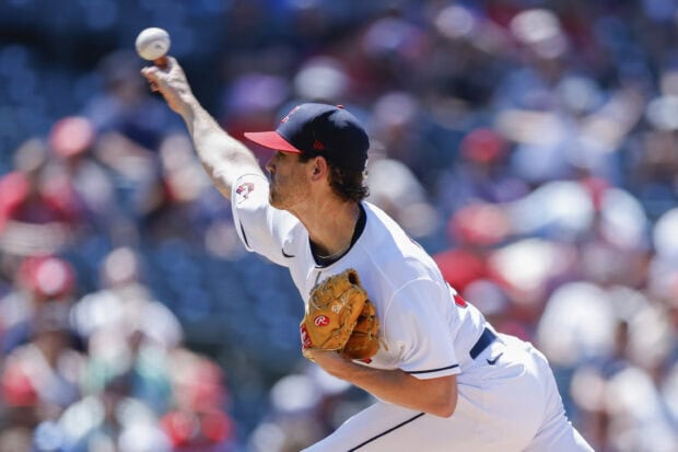 A Cleveland Guardians pitcher delivering a fastball during a baseball game in a packed stadium