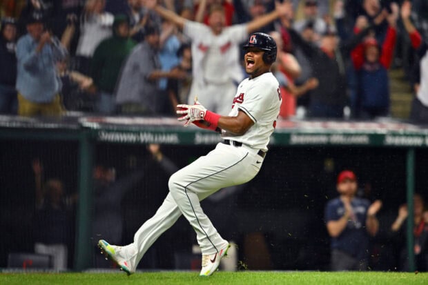 Cleveland Guardians player celebrating a key moment on the baseball field in front of cheering fans