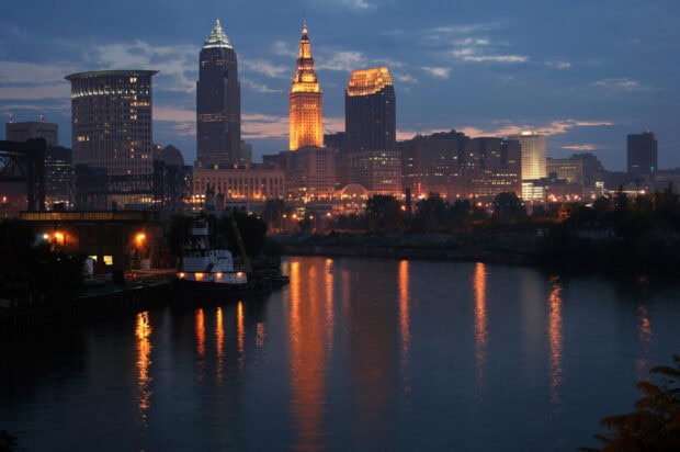 Cleveland city skyline with illuminated buildings reflecting on the river at dusk