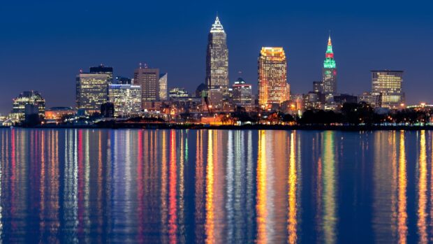 Nighttime cityscape of Cleveland with colorful reflections on the water