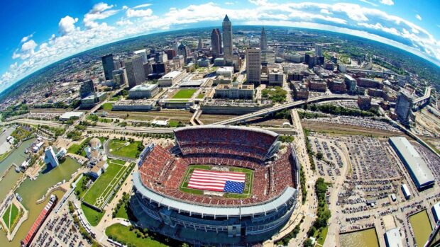 Aerial view of Cleveland city featuring a stadium with an American flag on the field