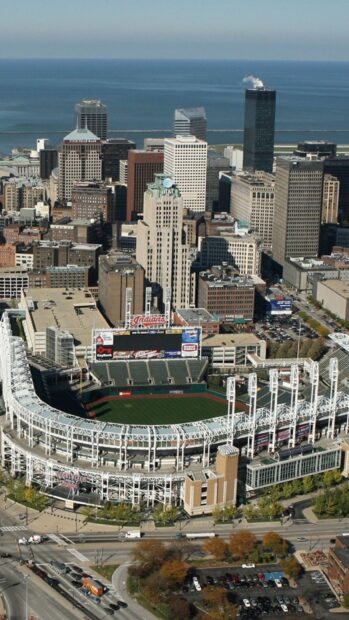Aerial view of Cleveland cityscape with a baseball stadium and downtown buildings on a clear day
