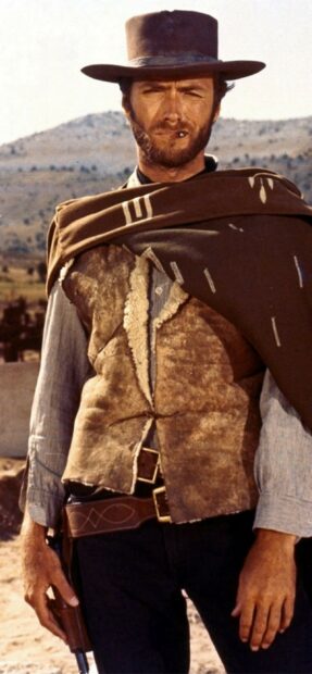 Clint Eastwood wearing a cowboy hat and vest with a gun in the desert background