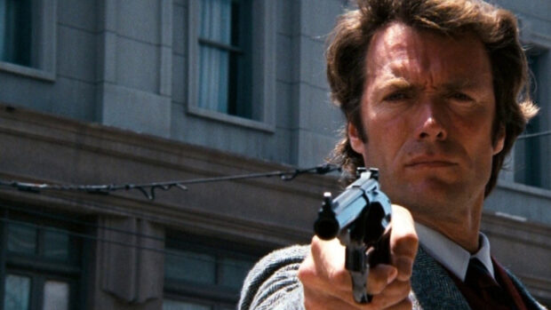Clint Eastwood aiming a gun with intense expression in a city setting