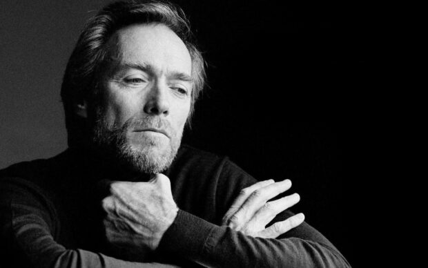 Clint Eastwood in a thoughtful pose with crossed arms and a beard