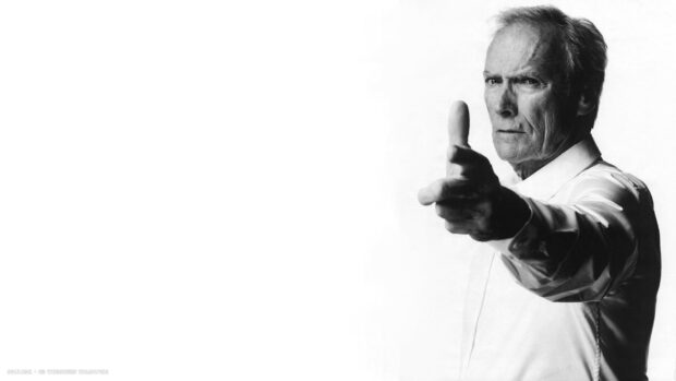 Clint Eastwood posing with a serious expression and pointing his hand like a gun gesture