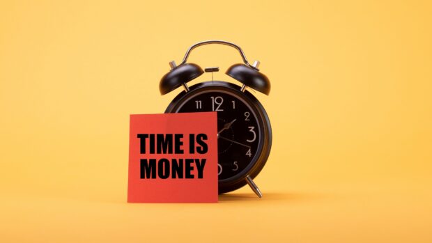 Black clock with time is money note on yellow background