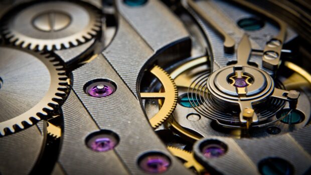 Close up of clock gears mechanism with intricate watch parts and purple jewels