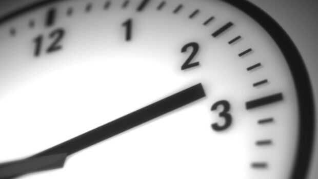 Close up of clock showing time near three with clear numbers and black hands