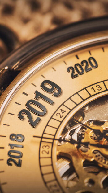 Close up of clock showing years 2018 2019 and 2020 with visible gears inside