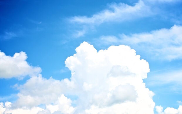 Large fluffy clouds floating in a bright blue sky with scattered smaller clouds