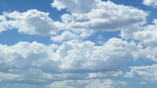 Fluffy clouds fill the bright blue sky creating a peaceful atmosphere