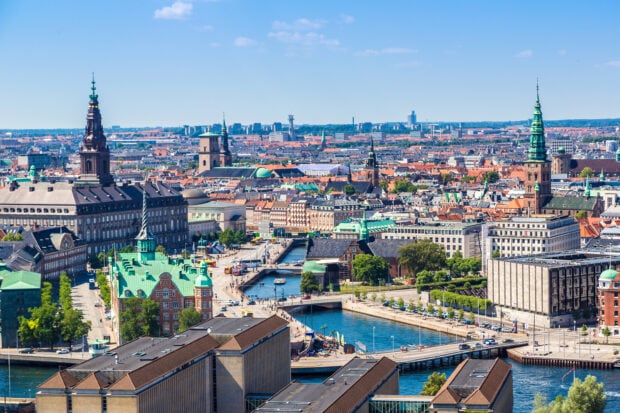 A panoramic view of Copenhagen cityscape with historic buildings and waterways on a clear day