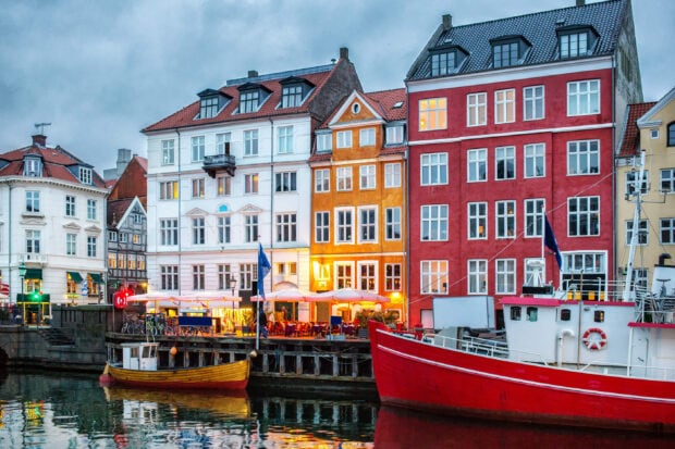Colorful buildings along the waterfront in Copenhagen with boats docked on the canal