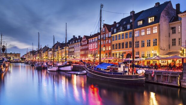 Colorful Copenhagen waterfront with boats and historic buildings at dusk in Copenhagen
