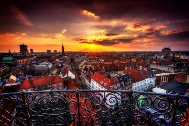 Sunset over Copenhagen cityscape with traditional rooftops and historic buildings