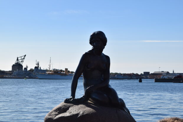 The statue of the mermaid sits on a rock overlooking the harbor in Copenhagen