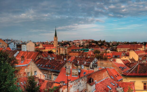 Historic Croatian town with red rooftops and a church tower under a cloudy sky