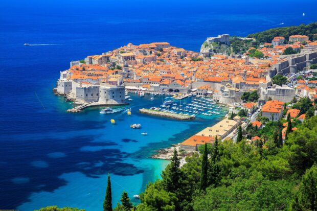 A panoramic view of Croatia showcasing the historic coastal town with red rooftops and blue sea