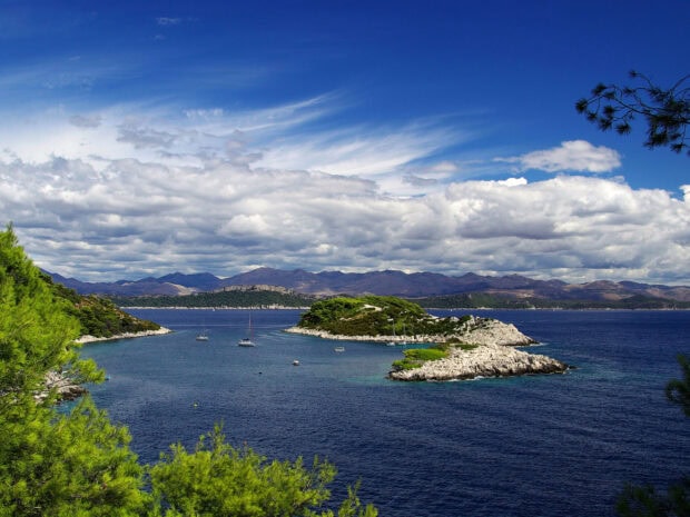 Beautiful Croatia coastline with islands and sailboats under a blue sky