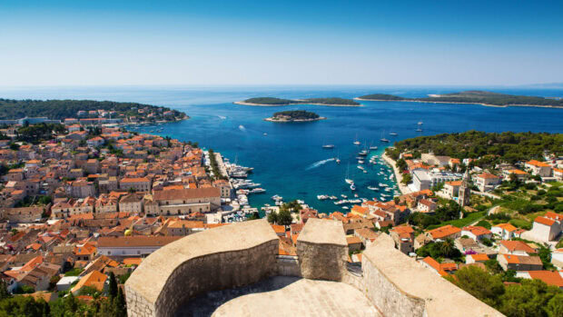 A panoramic view of a Croatian coastal town with clear blue sea and islands in the distance
