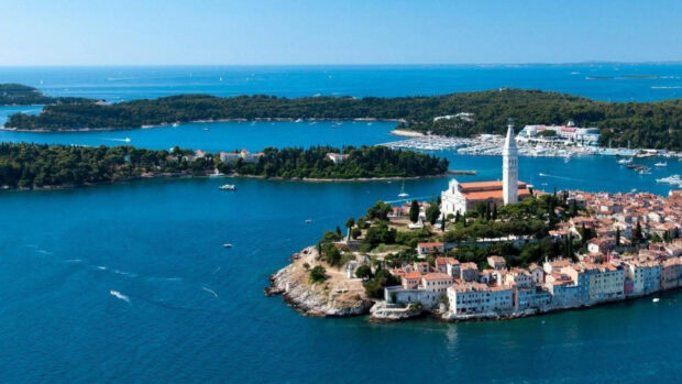 A scenic view of a coastal town in Croatia with a church tower and surrounding islands
