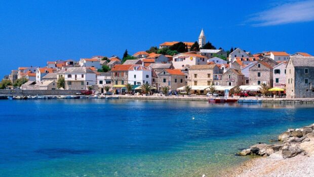 Coastal town in Croatia showcasing traditional stone houses and clear blue sea with bright sky