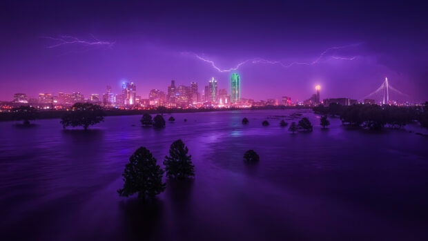 Nighttime cityscape of Dallas Texas with lightning striking above the skyline