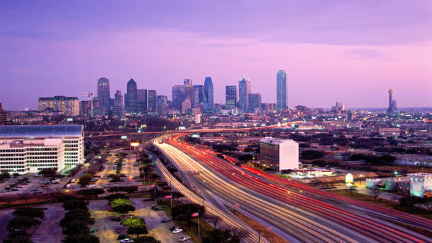 Evening view of Dallas Texas city skyline with busy highway lights