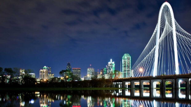 Dallas skyline with the Margaret Hunt Hill Bridge lit up at night in Dallas Texas