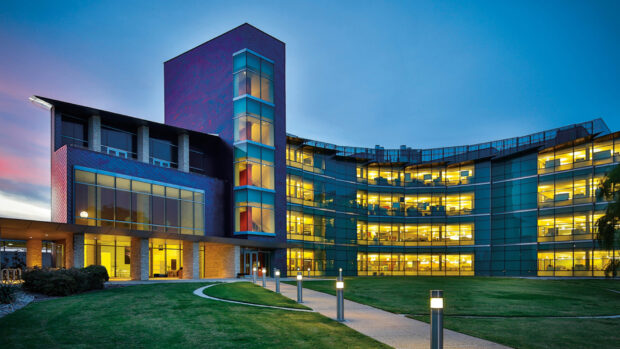 Modern office building in Dallas Texas with illuminated windows at dusk
