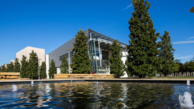 Modern architecture surrounded by tall trees in Dallas Texas with clear blue sky