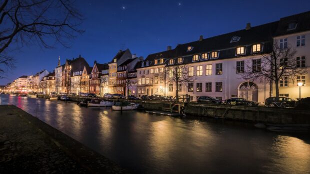 Historic Denmark waterfront buildings reflecting on canal water at night