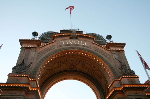 The iconic Tivoli entrance arch in Denmark with detailed architecture and a Danish flag above