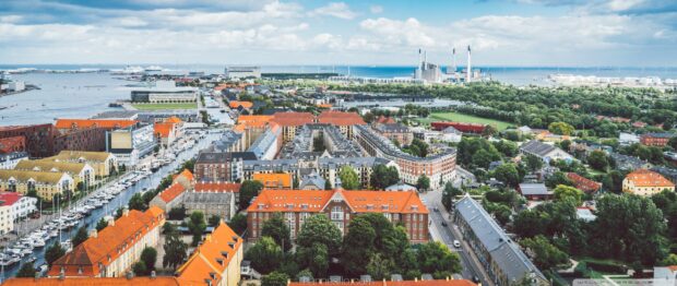Aerial view of Denmark cityscape with orange rooftops and harbor by the sea