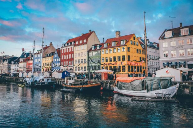 Colorful Denmark cityscape with boats docked along the waterfront and traditional architecture